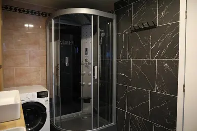 a shower with a glass door in a bathroom at Cozy family home near LottoArena Antwerpen in Antwerp