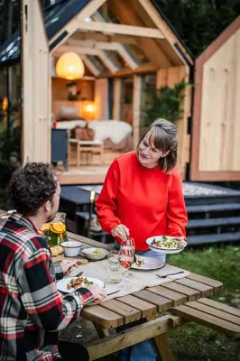 a man and a woman sitting at a picnic table at Sterrenhuisje aan de Beddermolen in Westerlo