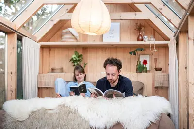 a man and a girl reading a book in a house at Sterrenhuisje aan de Beddermolen in Westerlo