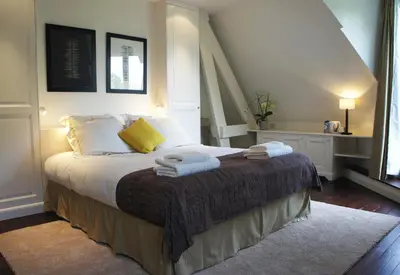 a bedroom with a bed with towels on it at Guest house La Maison Chantecler in Brussels