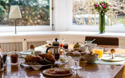 a table with food and drinks on it at Guest house La Maison Chantecler in Brussels