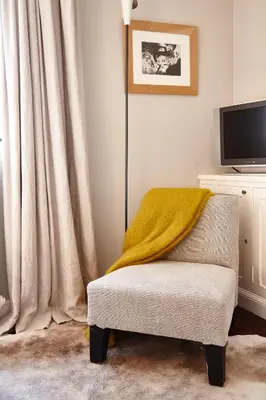 a living room with a chair and a television at Guest house La Maison Chantecler in Brussels