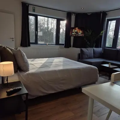 a bedroom with a large bed and a couch at Orient Herent - Boetiekhotel in Herent