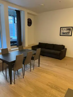a living room with a table and chairs and a couch at Brussels European flat in Brussels