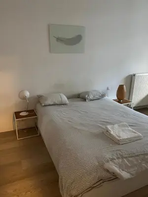 a white bed with two pillows on top of it at Brussels European flat in Brussels
