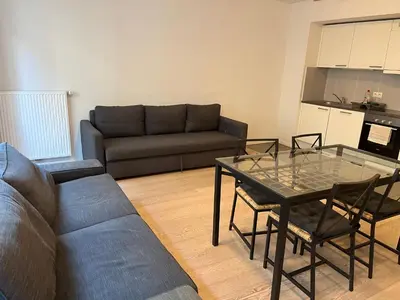 a living room with a couch and a glass table at Brussels European flat in Brussels