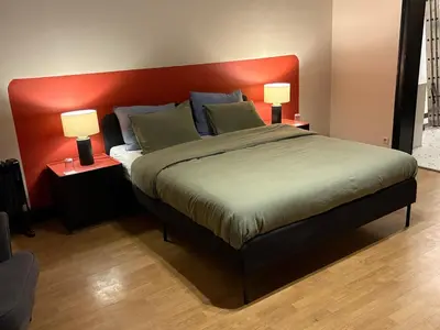 a bedroom with a large bed with a red headboard at Your Haven of Peace! in Brussels