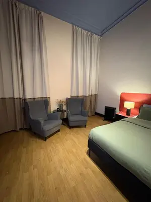 a hotel room with a bed and two chairs at Your Haven of Peace! in Brussels
