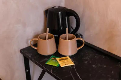 two coffee mugs on a table with a coffee pot at 3 Stylish Studios at a Great Location in Gent in Ghent