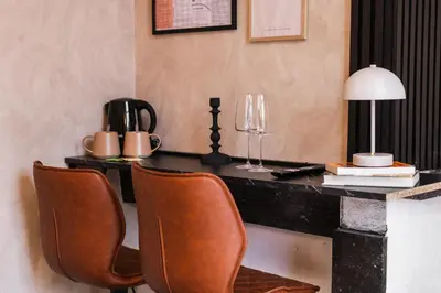 a desk with two chairs and a table with a lamp at 3 Stylish Studios at a Great Location in Gent in Ghent