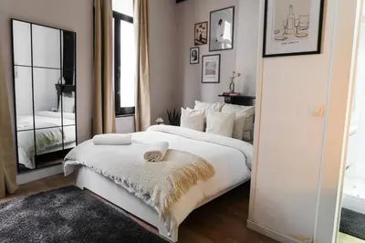 a bedroom with a large white bed and a mirror at 3 Stylish Studios at a Great Location in Gent in Ghent