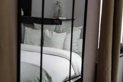 a room with a bed with white pillows at 3 Stylish Studios at a Great Location in Gent in Ghent