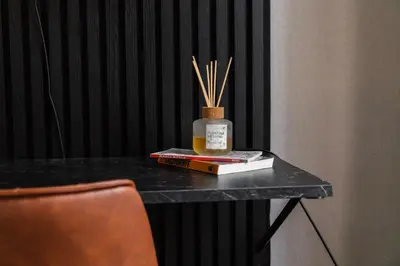 a table with books and a bottle of honey and bamboo sticks at 3 Stylish Studios at a Great Location in Gent in Ghent