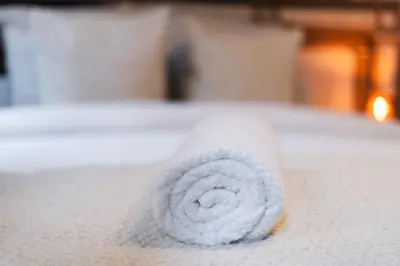 a roll of white towels on a bed at 3 Stylish Studios at a Great Location in Gent in Ghent