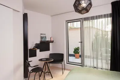 a bedroom with a window and a table and chairs at B&B Lucy in the Sky in Antwerp