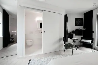 a bedroom with a door leading to a bathroom with a toilet at B&B Lucy in the Sky in Antwerp