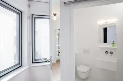 a white bathroom with a toilet and a window at B&B Lucy in the Sky in Antwerp