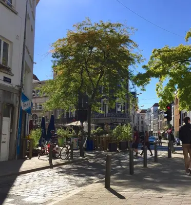 a city street with people walking on the sidewalk at B&B Lucy in the Sky in Antwerp