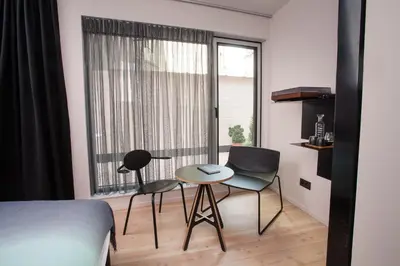 a bedroom with a bed and two chairs and a table at B&B Lucy in the Sky in Antwerp