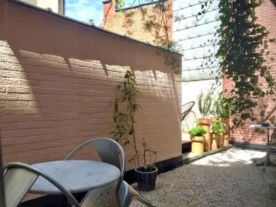 a patio with a chair and a plant next to a wall at B&B Lucy in the Sky in Antwerp