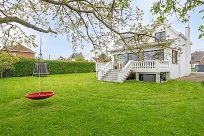 a red frisbee in the grass in front of a house at The Beautiful White House in Kortenberg