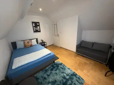 a small bedroom with a bed and a couch at The Beautiful White House in Kortenberg