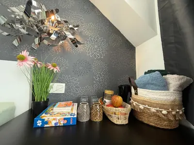 a table with baskets and books and a chandelier at The Beautiful White House in Kortenberg