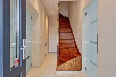 a hallway with a wooden staircase in a house at The Beautiful White House in Kortenberg