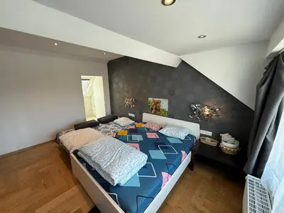 a bedroom with a bed with a blue comforter at The Beautiful White House in Kortenberg
