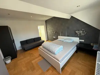 a large bedroom with a bed and a couch at The Beautiful White House in Kortenberg