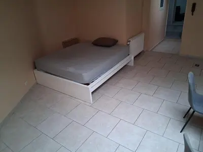 a small bedroom with a bed and a tiled floor at Bruxelles IN in Brussels
