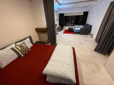 a bedroom with a bed and a living room at The Beautiful White Villa in Kortenberg