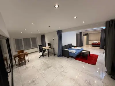 a living room with a blue bed and a desk at The Beautiful White Villa in Kortenberg