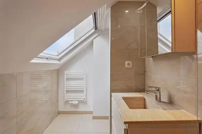 a bathroom with a sink and a skylight at The Beautiful White Villa in Kortenberg