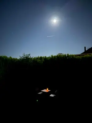 a table in the middle of a field at night at The Beautiful White Villa in Kortenberg