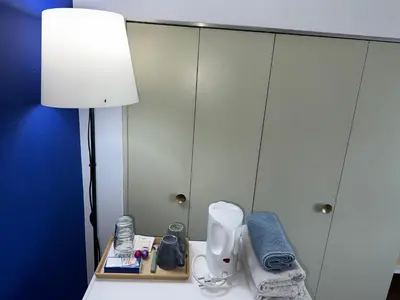a lamp sitting on a table next to a cabinet at The Beautiful White Villa in Kortenberg