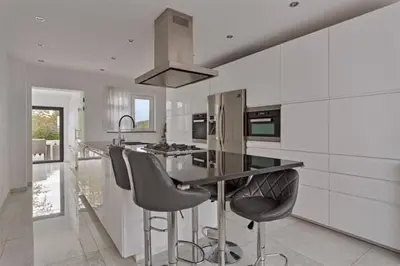 a kitchen with a counter and stools in it at The Beautiful White Villa in Kortenberg