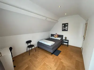 a small bedroom with a bed and a desk at The Beautiful White Villa in Kortenberg