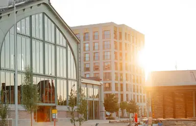 a large glass building with the sun in the background at Brussels City Chambers in Brussels