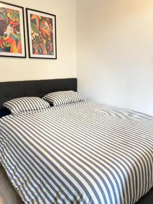 a bed with striped sheets in a bedroom at Brussels City Chambers in Brussels