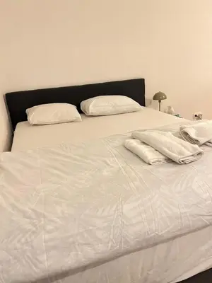 a white bed with white sheets and pillows on it at Brussels City Chambers in Brussels