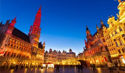 a large building with a clock tower at night at Bel appartement proche de tout in Brussels