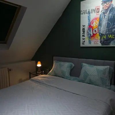 a bedroom with a bed with a poster on the wall at Balacobaco in Brussels