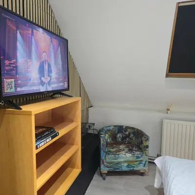 a living room with a tv and a chair at Balacobaco in Brussels