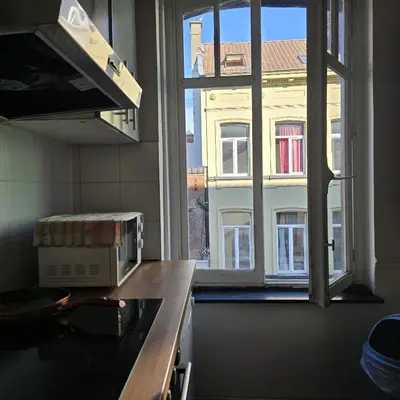a kitchen with a window looking out at a building at Balacobaco in Brussels