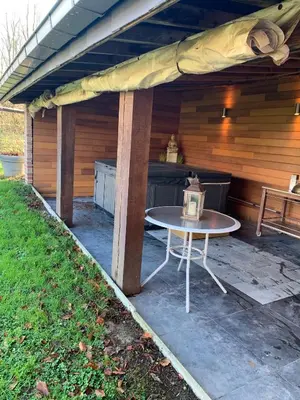 a patio with a table in front of a cabin at Sous un toit perché in Grez-Doiceau