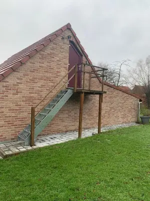 a staircase on the side of a brick building at Sous un toit perché in Grez-Doiceau