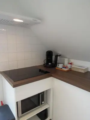 a kitchen with a counter top and a microwave at Sous un toit perché in Grez-Doiceau