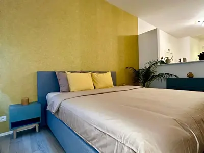 a bedroom with a large bed with yellow walls at Luxury Suites Royal by Rikas Hotels in Antwerp