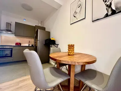 a kitchen and dining room with a wooden table and chairs at Luxury Suites Royal by Rikas Hotels in Antwerp